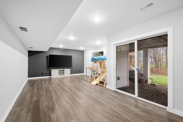 interior space featuring baseboards, wood finished floors, and visible vents