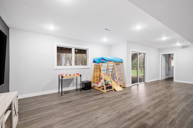 recreation room featuring plenty of natural light, baseboards, wood finished floors, and visible vents