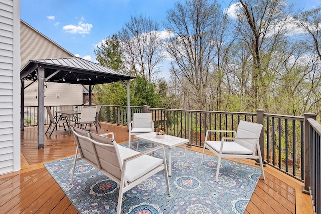 deck with outdoor dining area and a gazebo