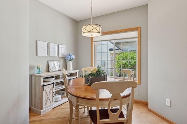 dining area featuring light wood finished floors and baseboards
