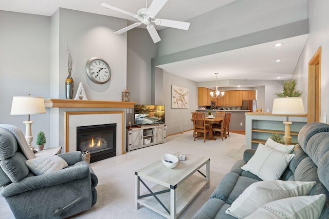 living area featuring a chandelier, a fireplace, ceiling fan, light carpet, and recessed lighting