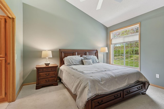 bedroom with vaulted ceiling, light colored carpet, baseboards, and a ceiling fan