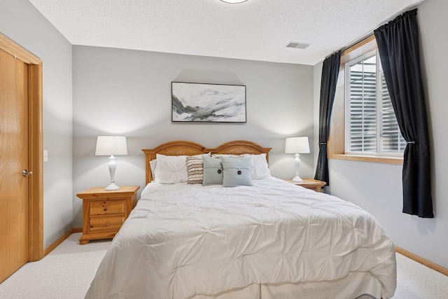 bedroom with carpet floors, baseboards, and a textured ceiling