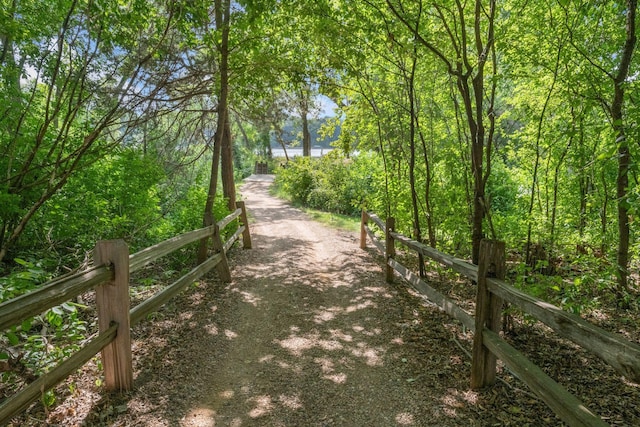 view of home's community with fence and a wooded view