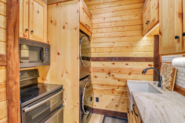 23351 County Highway 22, Lake View Twp, MN 56501 - laundry room featuring wooden walls, laundry area, a sink, and stacked washer / dryer