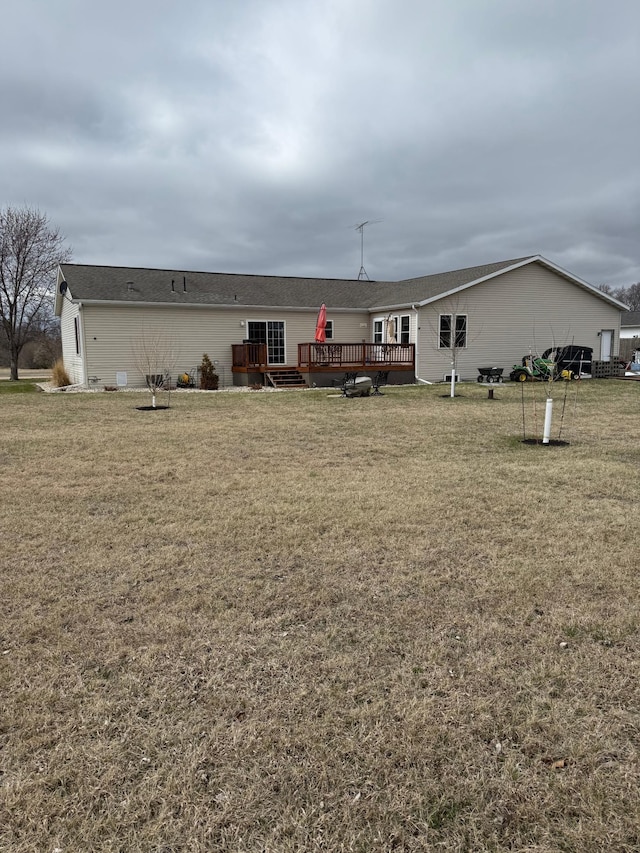 rear view of house featuring a yard and a wooden deck