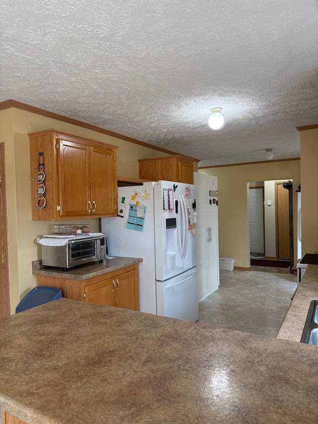 kitchen featuring a toaster, white refrigerator with ice dispenser, and brown cabinets