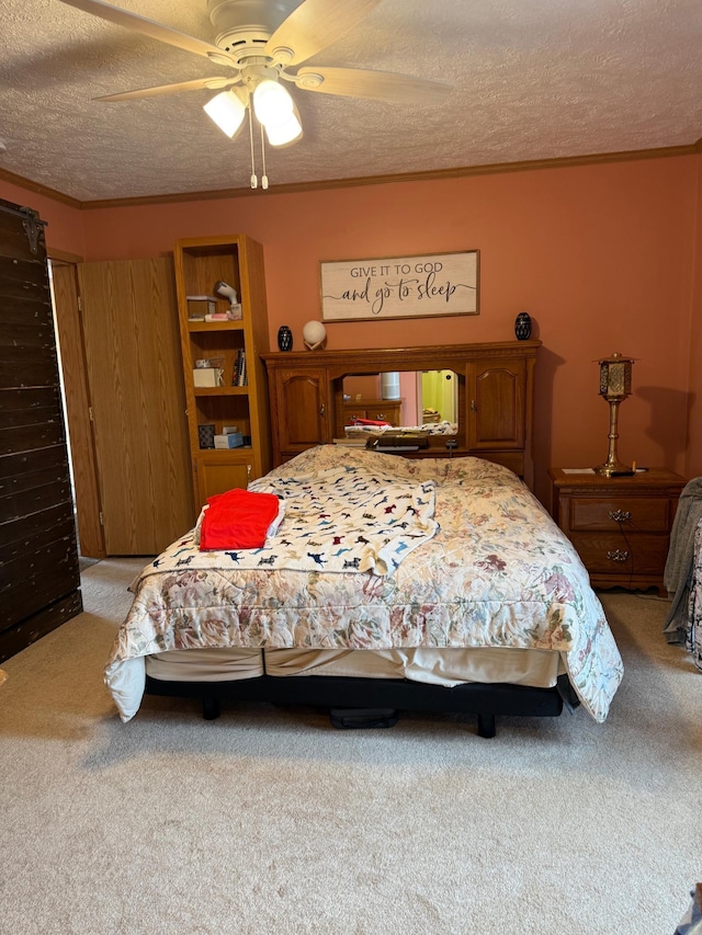 bedroom with crown molding, a ceiling fan, a textured ceiling, and light colored carpet
