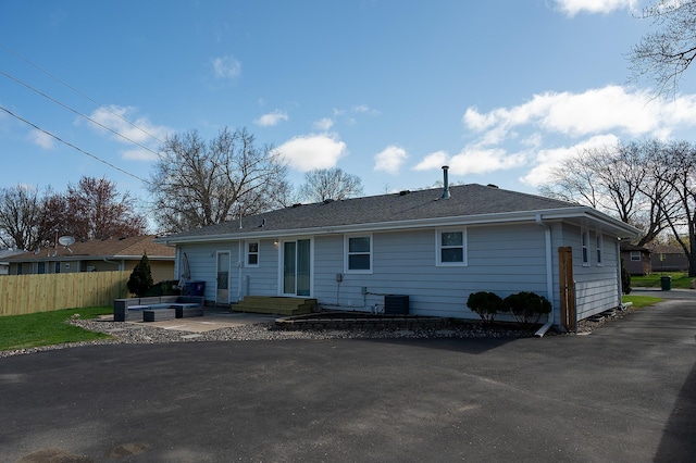 rear view of house with fence, an outdoor hangout area, a patio area, and central AC