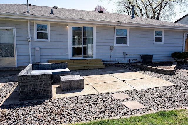 rear view of property featuring entry steps, central AC unit, an outdoor living space, and a patio area