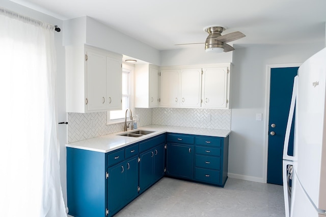 kitchen featuring a sink, a ceiling fan, backsplash, and freestanding refrigerator