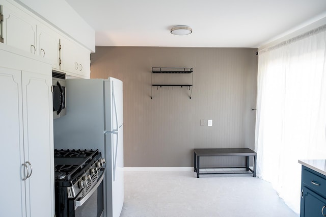 kitchen featuring blue cabinets, white cabinetry, appliances with stainless steel finishes, and light countertops