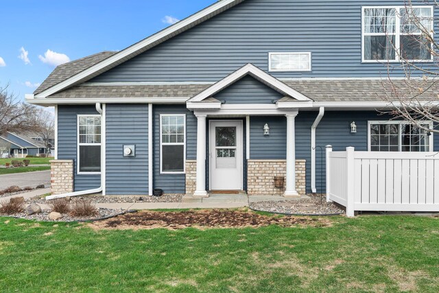 view of front facade featuring a shingled roof and a front lawn