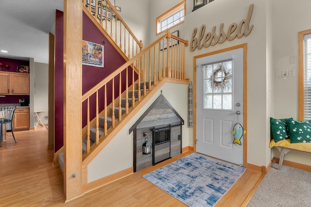 entryway with a healthy amount of sunlight, baseboards, and stairs