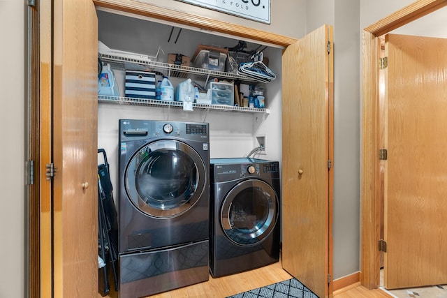 laundry room with wood finished floors, laundry area, and washing machine and dryer