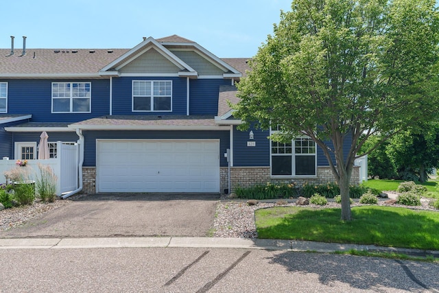 428 Hickory Ln N, Oakdale, MN 55128 - view of front facade with stone siding, driveway, an attached garage, and a shingled roof