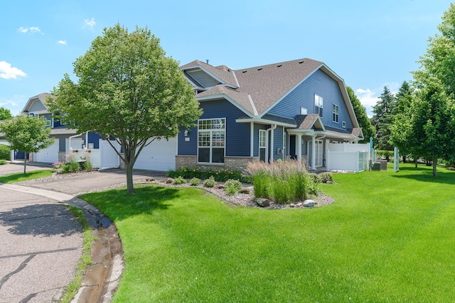 428 Hickory Ln N, Oakdale, MN 55128 - view of front facade featuring a front yard, driveway, and a shingled roof