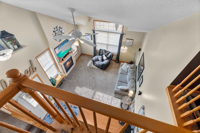 428 Hickory Ln N, Oakdale, MN 55128 - living area with a ceiling fan, a lit fireplace, carpet floors, plenty of natural light, and a textured ceiling