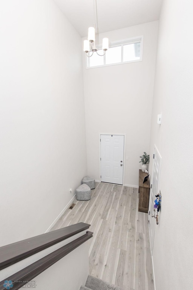 interior space featuring baseboards, a chandelier, and wood finished floors