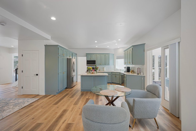 kitchen with a center island, appliances with stainless steel finishes, plenty of natural light, and green cabinets
