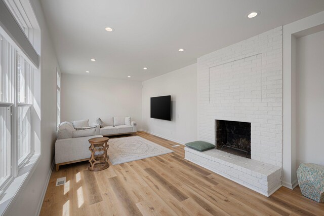 living area featuring visible vents, recessed lighting, wood finished floors, and a fireplace