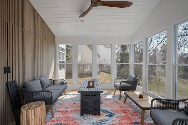sunroom / solarium with a ceiling fan and an outdoor living space with a fire pit