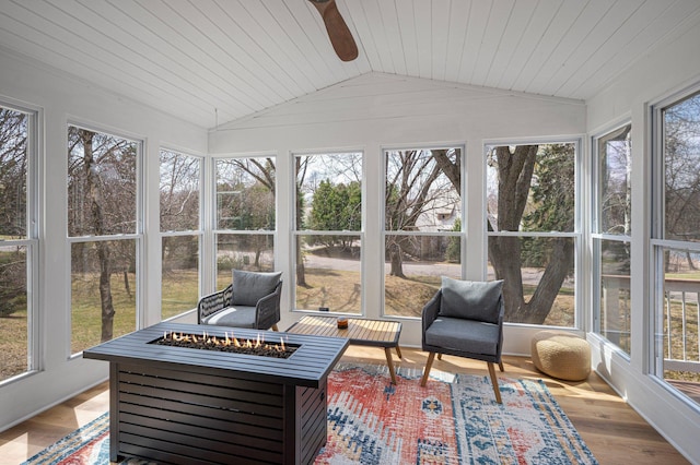sunroom with a ceiling fan, vaulted ceiling, wood finished floors, and an outdoor fire pit