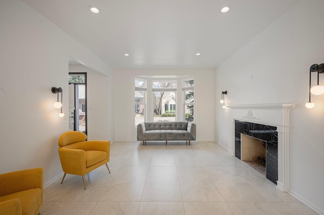living area featuring a premium fireplace, baseboards, and recessed lighting