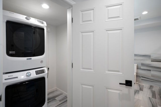 washroom with laundry area, stacked washing maching and dryer, recessed lighting, baseboards, and visible vents