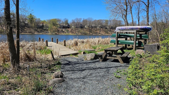surrounding community featuring a boat dock and a water view