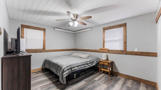 bedroom with wood finished floors, baseboards, and ceiling fan