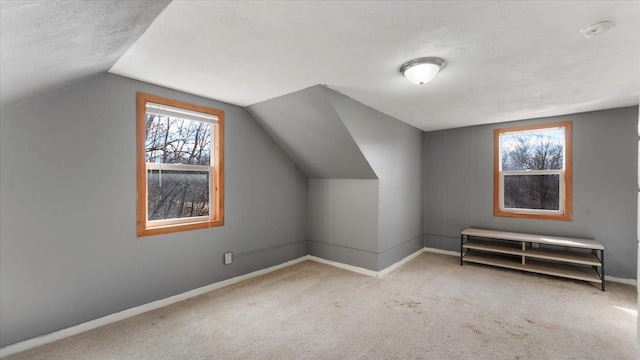 additional living space with carpet floors, vaulted ceiling, and baseboards
