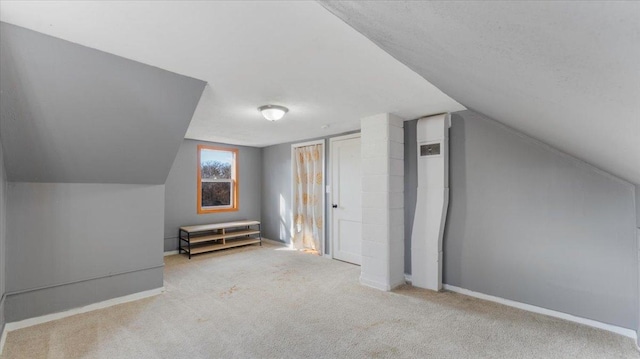 additional living space with carpet floors, lofted ceiling, and baseboards