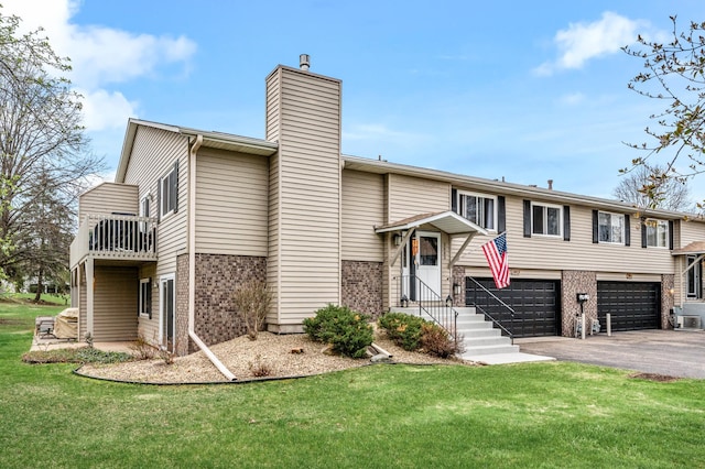 3903 Gershwin Ave N, Oakdale, MN 55128 - bi-level home featuring driveway, a chimney, a front yard, brick siding, and an attached garage