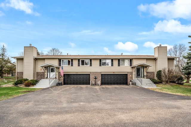 3903 Gershwin Ave N, Oakdale, MN 55128 - bi-level home with driveway, a chimney, central AC unit, and a garage