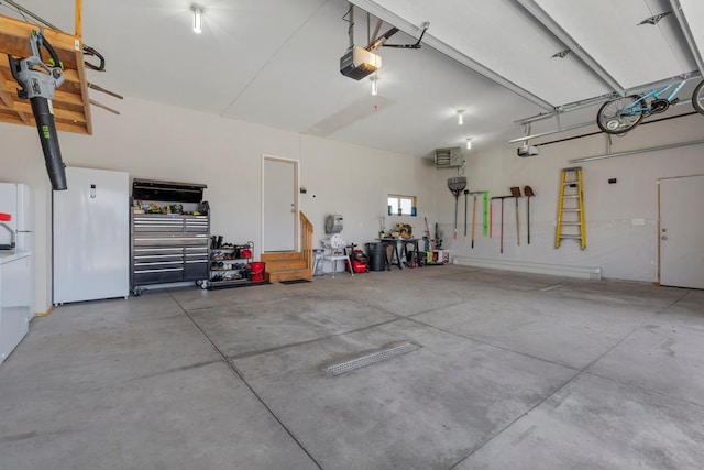 2120 Violet Ln, Faribault, MN 55021 - garage featuring a garage door opener and freestanding refrigerator