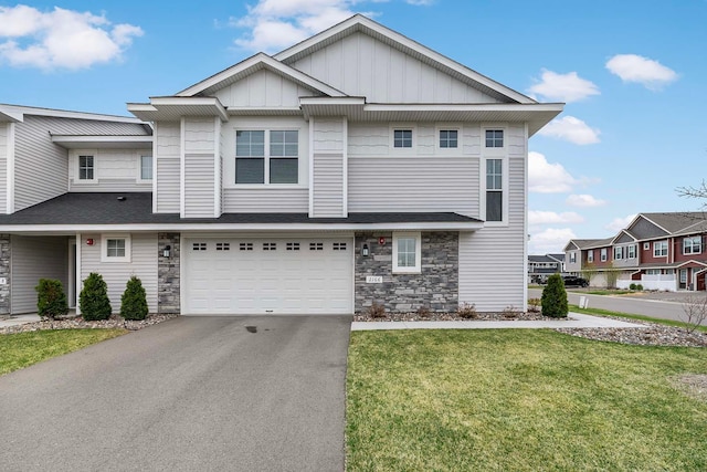 2166 Island Ct, Lino Lakes, MN 55038 - view of property featuring asphalt driveway, board and batten siding, a front yard, an attached garage, and stone siding