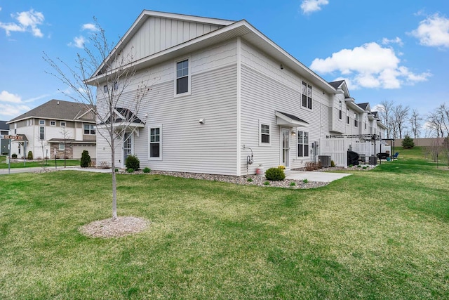 2166 Island Ct, Lino Lakes, MN 55038 - view of property exterior featuring board and batten siding, a lawn, central AC, and a residential view
