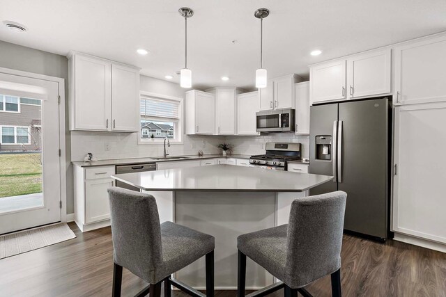 2166 Island Ct, Lino Lakes, MN 55038 - kitchen featuring stainless steel appliances, dark wood-type flooring, a sink, a breakfast bar area, and recessed lighting