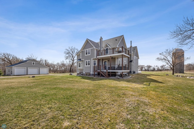 back of property featuring a garage, an outdoor structure, a lawn, and a balcony