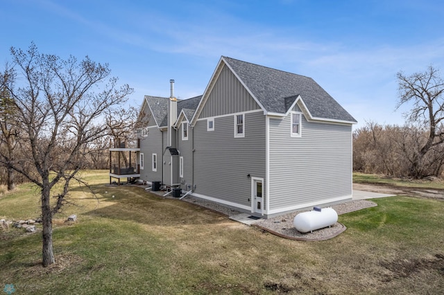 view of side of home with roof with shingles, board and batten siding, and a yard