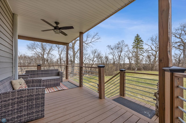 wooden deck featuring a lawn and a ceiling fan