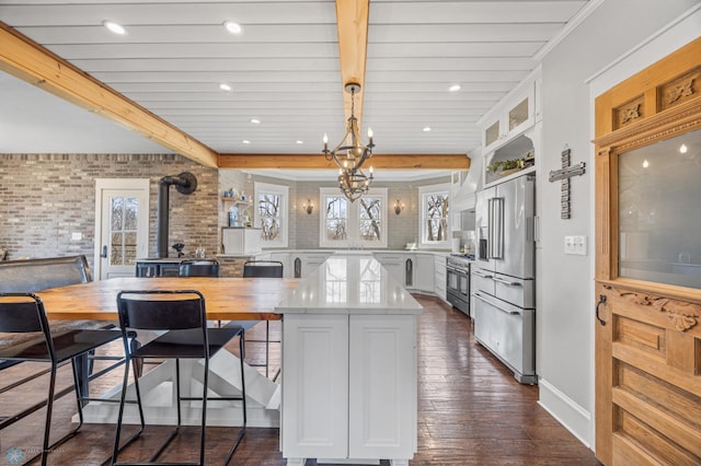 kitchen with a healthy amount of sunlight, white cabinets, premium appliances, and dark wood-style flooring