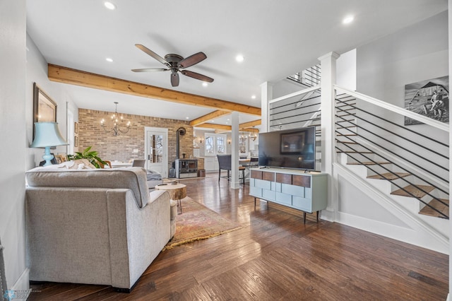 living room with brick wall, stairway, beamed ceiling, ceiling fan with notable chandelier, and recessed lighting