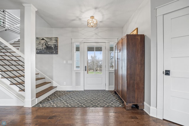 foyer entrance featuring wood-type flooring, baseboards, and stairs