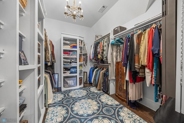 spacious closet with wood finished floors, a chandelier, and visible vents