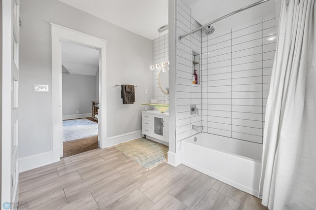 bathroom with vanity, baseboards, shower / bath combo, and wood finished floors