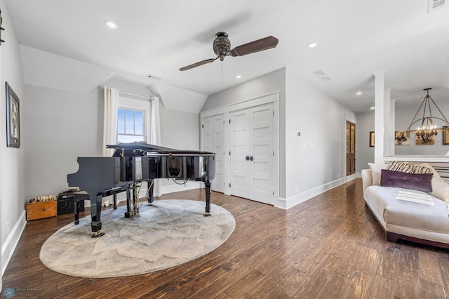 living area featuring baseboards, lofted ceiling, wood finished floors, and ceiling fan with notable chandelier
