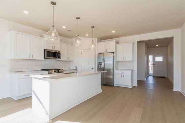 15149 Quince St NW, Andover, MN 55304 - kitchen with stainless steel appliances, light wood-style floors, a sink, and tasteful backsplash