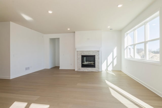 15149 Quince St NW, Andover, MN 55304 - unfurnished living room with recessed lighting, baseboards, a stone fireplace, and light wood-style flooring